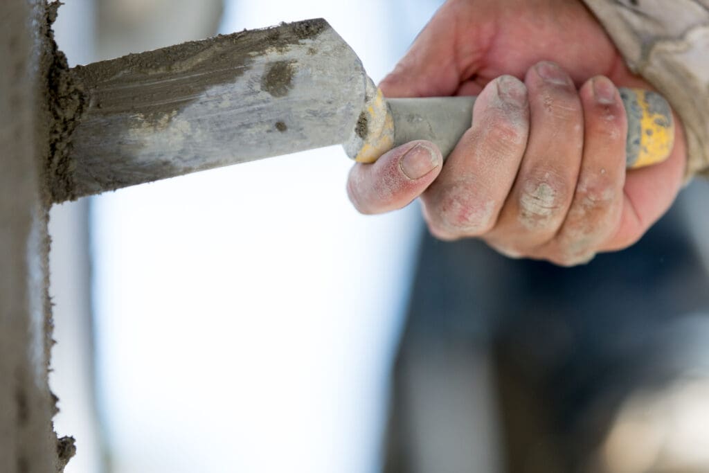 Technician repairing a small crack in a residential stucco wall